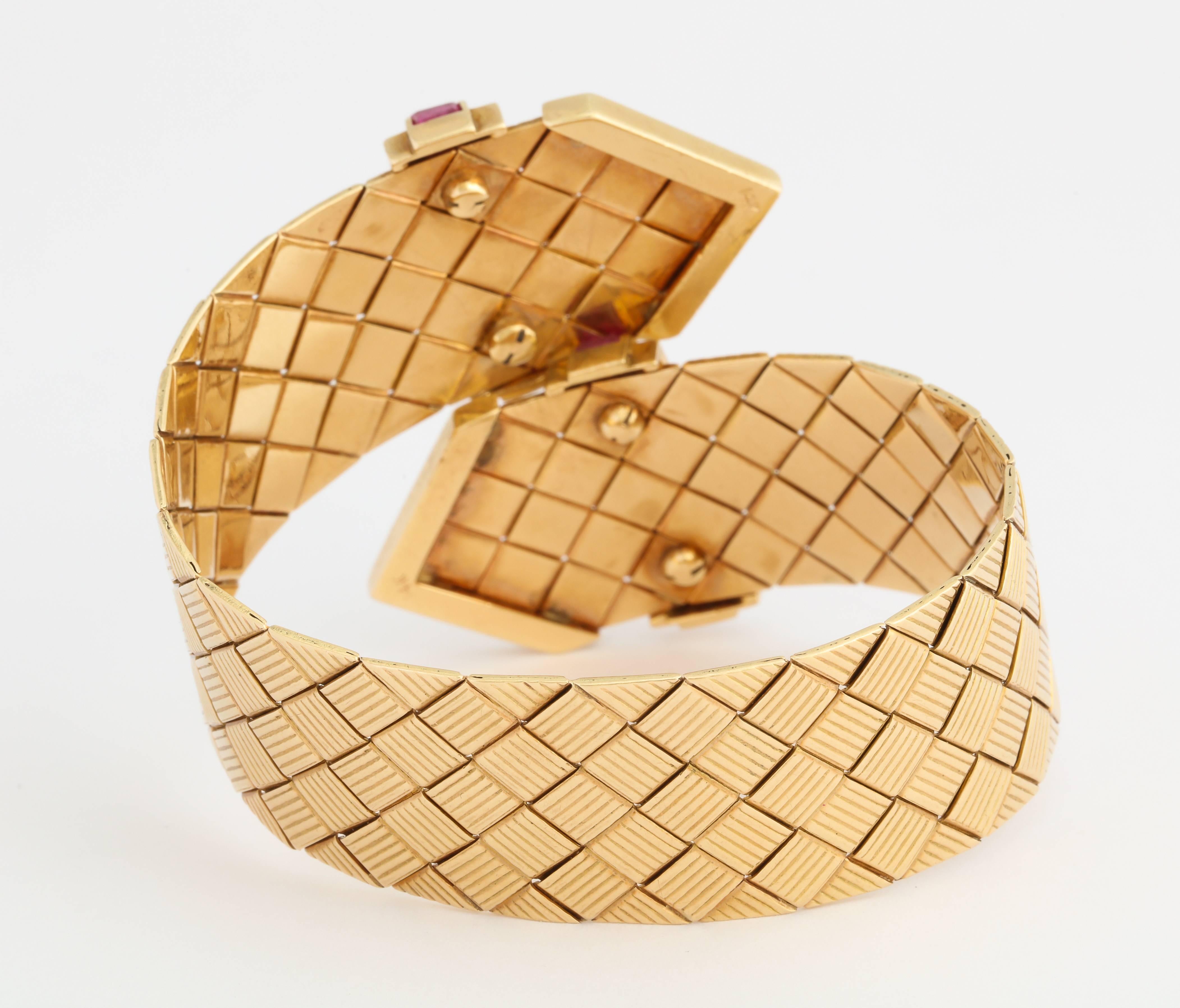 Retro with a modern look, this 1940s crossover bracelet of 14K gold in a basketweave pattern, features bands of matched square-cut rubies, and has a firm springy grip. 2 inches at it's widest, it nicely fits a 6 1/2 inch to a 7 1/2 inch wrist. 