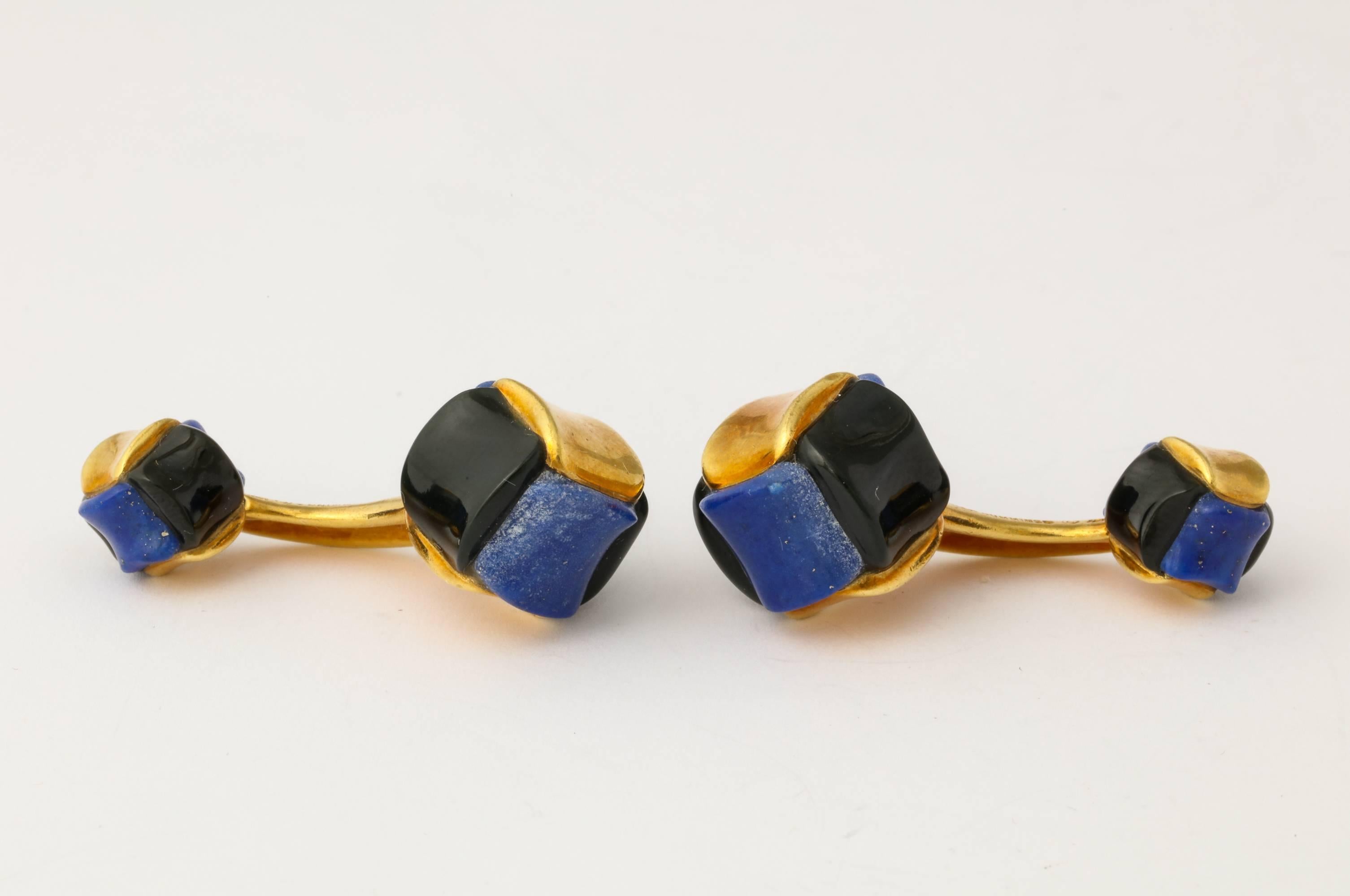 Handsome and one-of-a-kind pair of cufflinks by Angela Cummings, custom ordered c1985, of 18K gold set with carved lapis lazuli and black jade, with an accent of translucent brown enamel in the connecting bar. Marked: Angela Cummings 18K. Largest