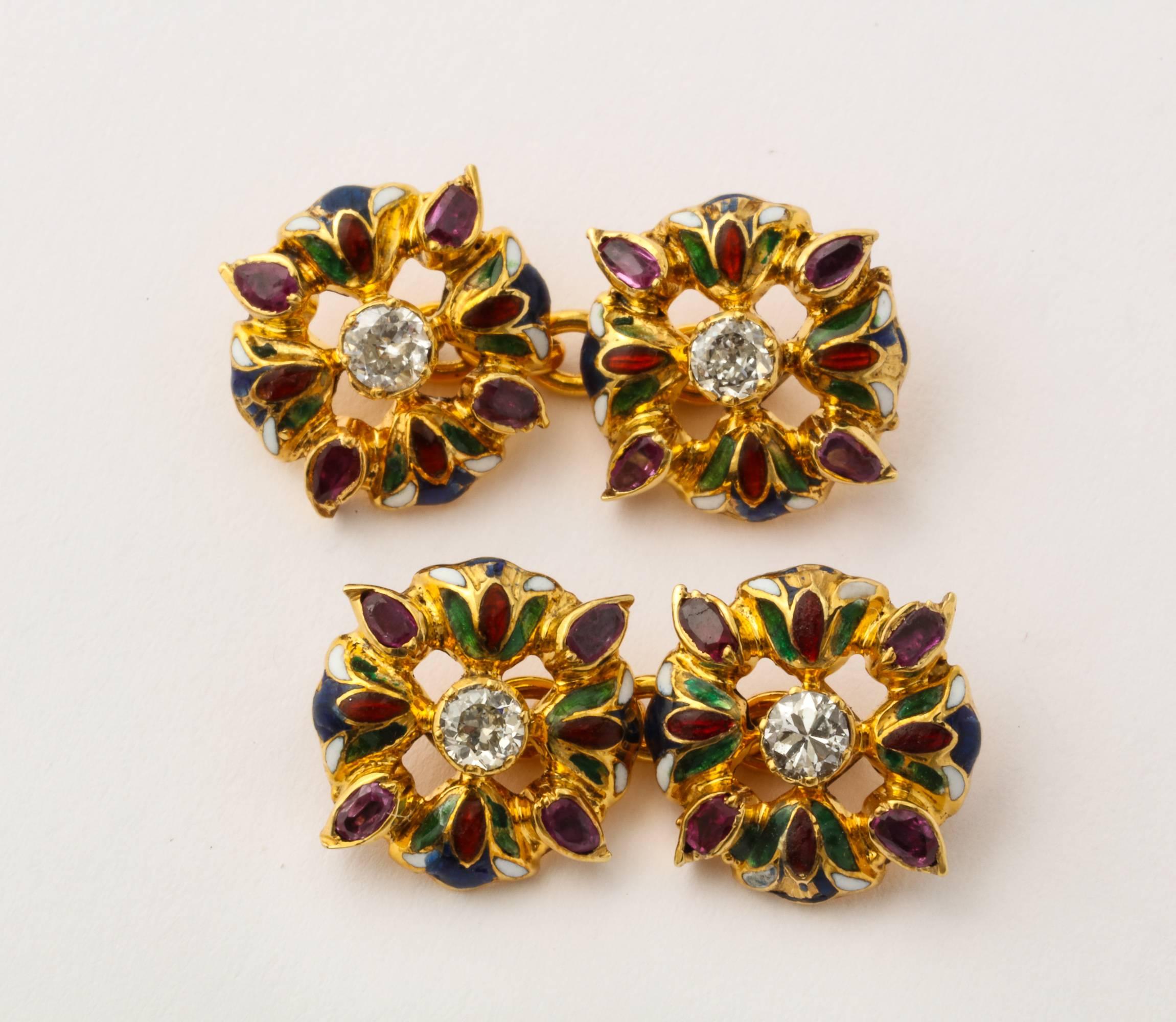 A beautiful Art Nouveau Egyptian style formal set of double side cufflinks and three studs in 18K gold, each element formed as four lotus flowers with green and red enameled petals, each centered with a diamond and a ruby set between each flower.