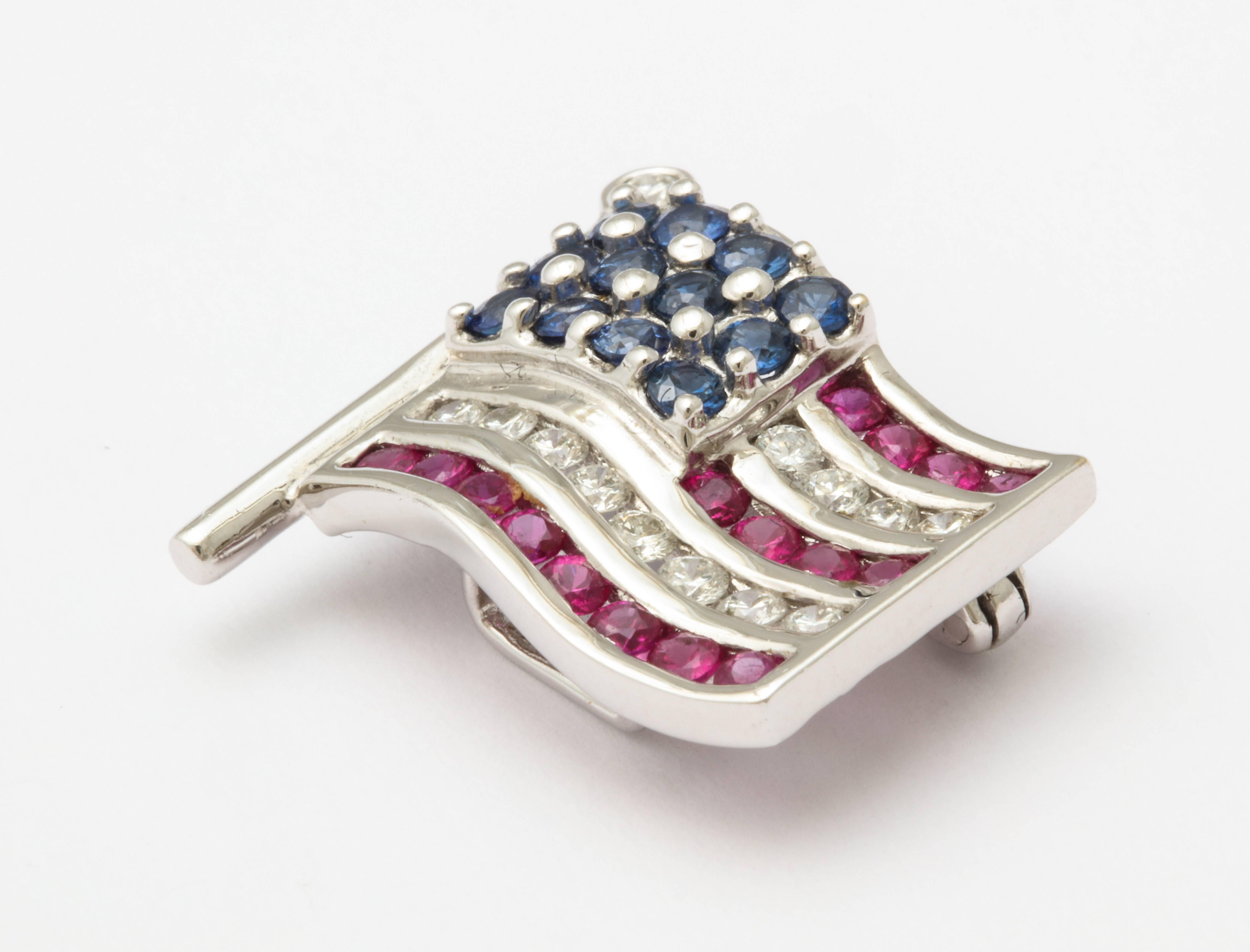 The perfect scale American flag lapel pin for Him or Her in 18K white gold, set with rubies, sapphires and diamonds. Dated 1990 in Roman numerals, marked 18K and 750, weighs 6.5 grams, and measures 3/4 inch x 3/4 inch. 