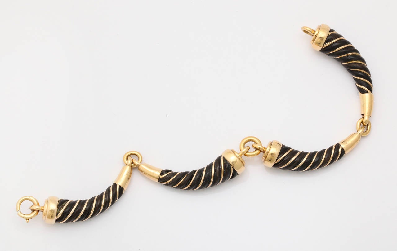 Remember these at Studio 54? Perfectly chic on a man or woman, this 1970's bracelet features four horn shaped segments of 18K gold wrapped in strands of lacquered mahogany brown elephant hair. Marked France, with gold mark and unidentified markers