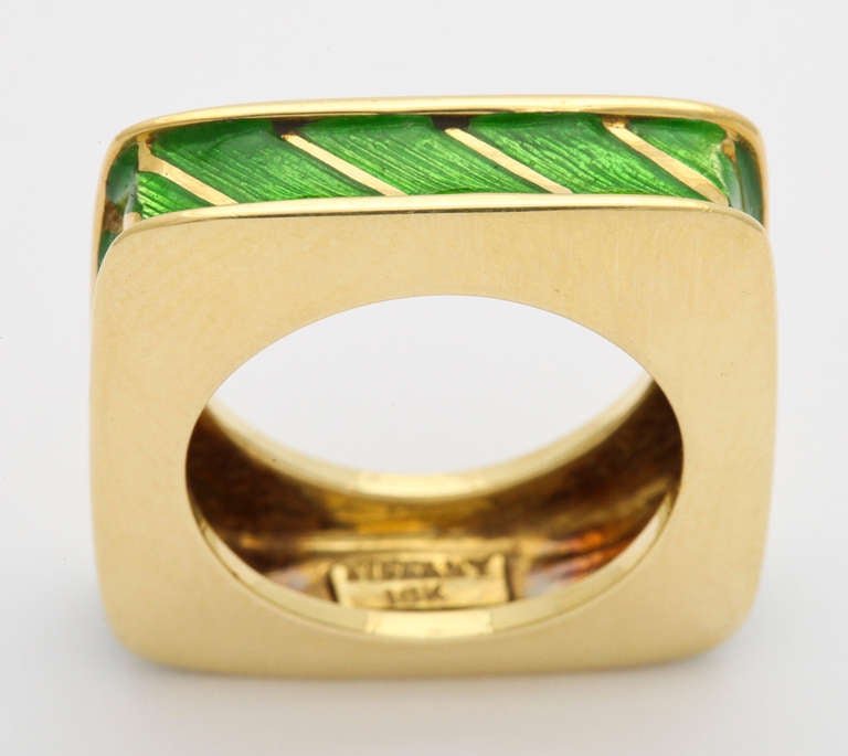 A stylish and very wearable 18K yellow gold Tiffany ring with the distinctive addition of translucent green enamel on a recessed hand textured ground. Tiffany and gold marks, 14.8 grams. Size 7 1/2.