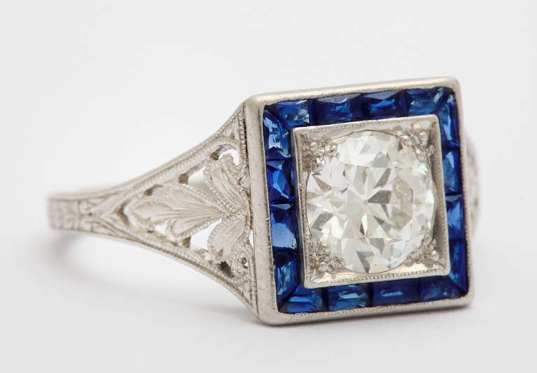 A beautiful 1923 custom made Tiffany & Co. platinum ring holding a 1.14 carat round brilliant cut diamond G VS1 (GIA #5151721643), surroounded by 16 fancy cut sapphires = .50 carats. Tiffany mark. Size 8 1/4. *Includes GIA certificate.