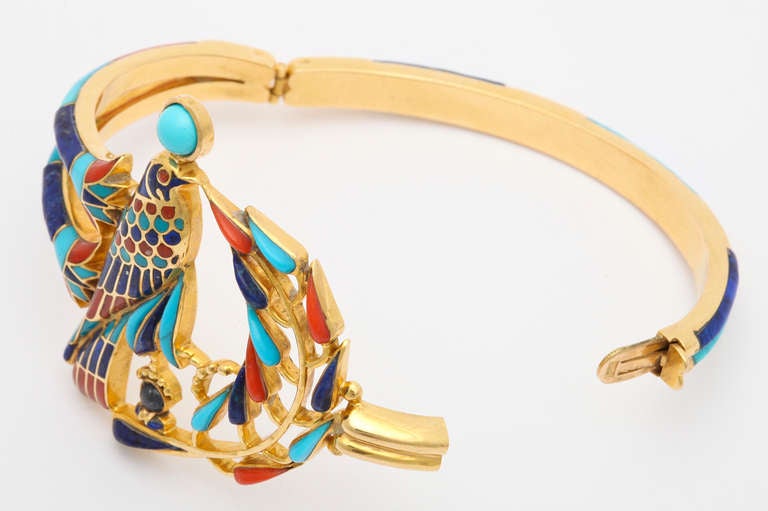 Made for the Tutankhamun Exhibition 1972.

A striking and artistic bracelet of 18K yellow gold in the Egyptian style, depicting Ra, the ruler of the heavens, set with natural red coral, lapis and turquoise stones carved in the manner of ancient