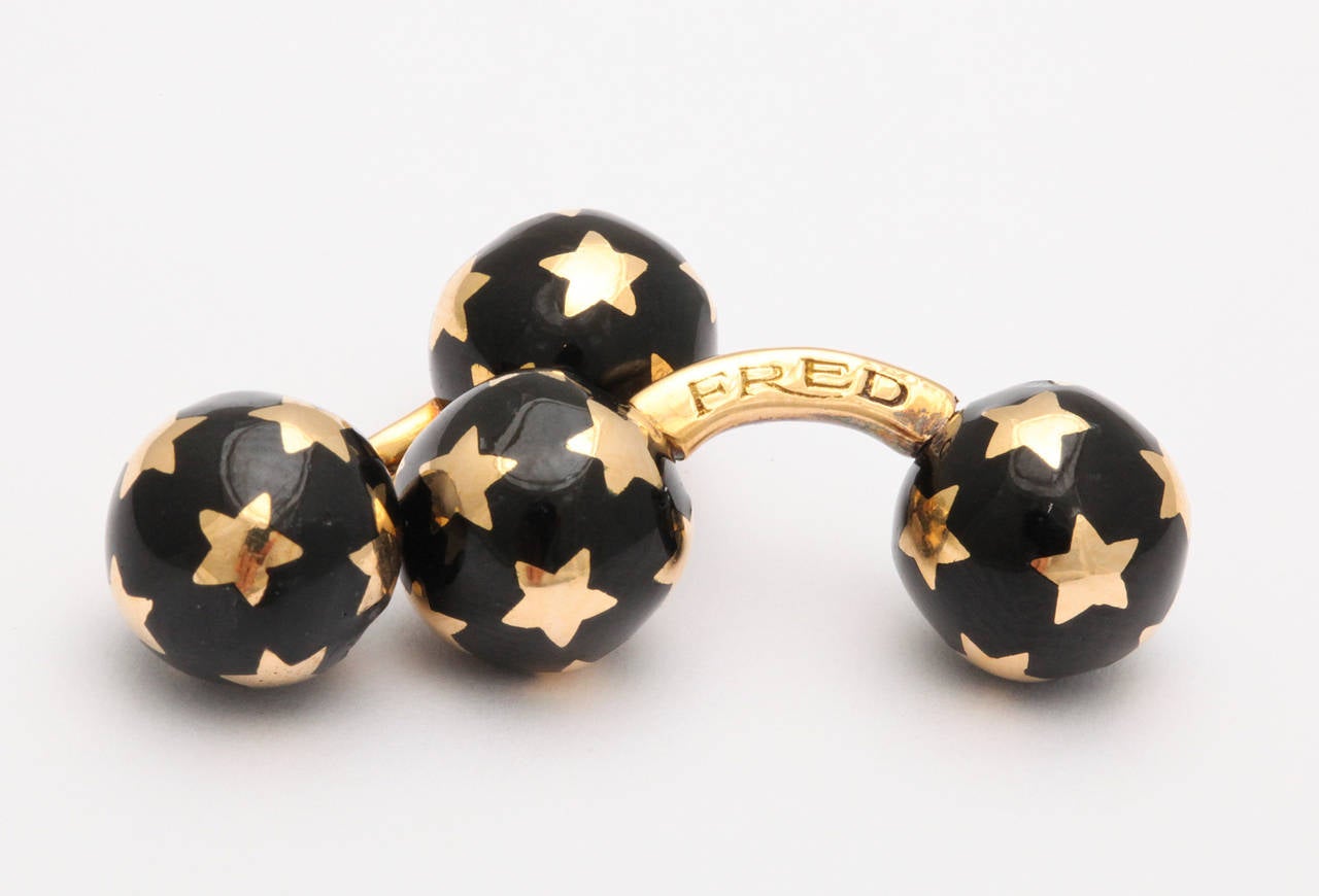Homme-chic ! Ces jolis boutons de manchette à boule en or 18 carats de Fred - Paris présentent des étoiles à cinq branches qui se détachent sur un champ d'émail noir de jais. Une boule sur chacun se dévisse pour une insertion facile dans n'importe