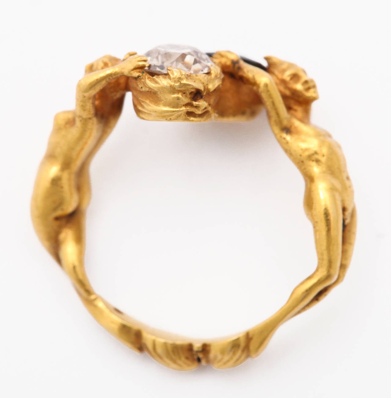 A beautifully detailed figural Art Nouveau ring of 18K gold comprised of a maiden holding a half carat diamond, and a faun character holding a deep blue  half carat sapphire. Unmarked. Fits a size finger size 3 1/2, but it would be easy to adjust