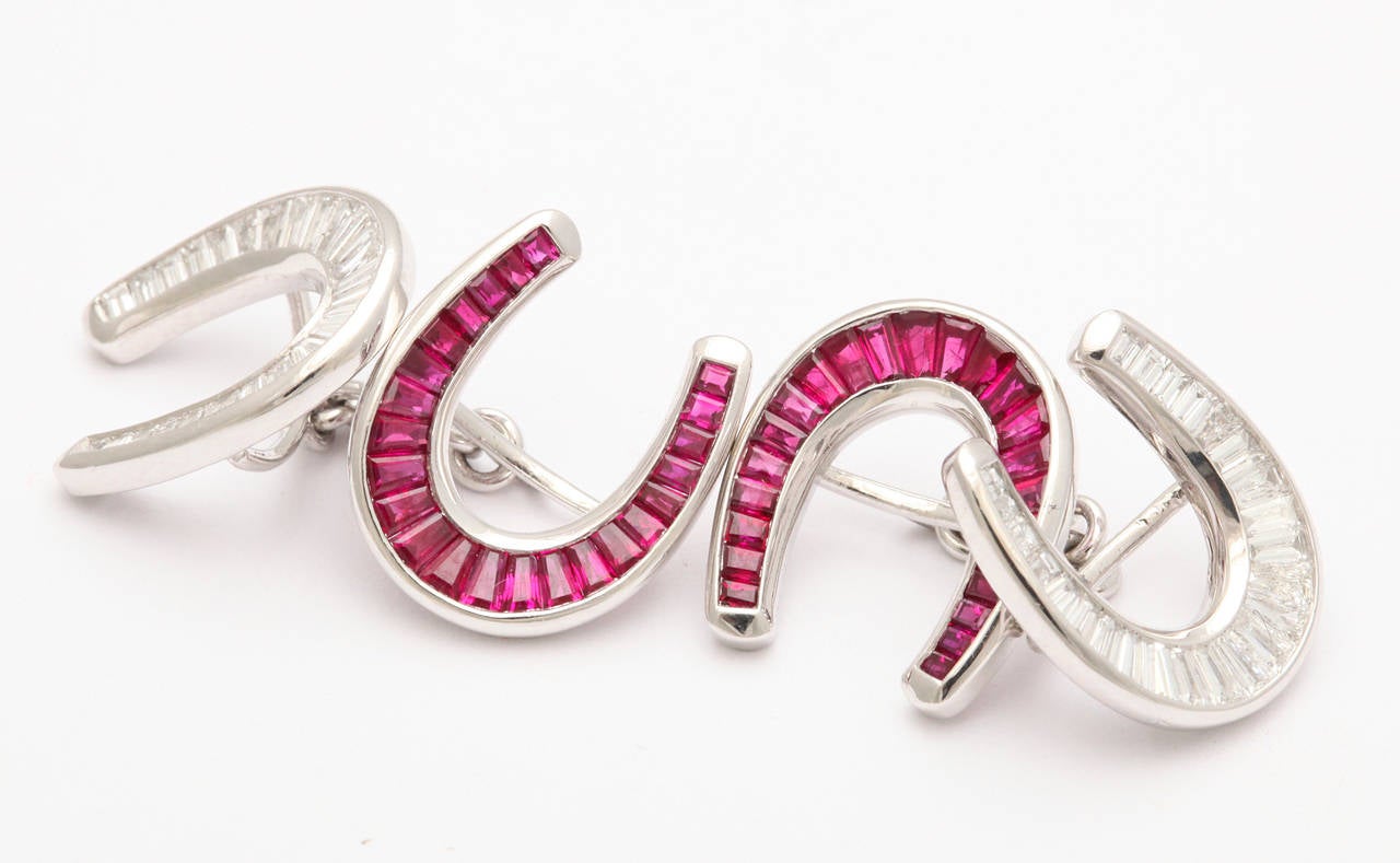 A handsome and elegant pair of lucky horseshoe shape cufflinks from Sophia D., in platinum set entirely with calibrated baguette rubies and diamonds. Platinum and maker's marks. 1 in. x 1 in.