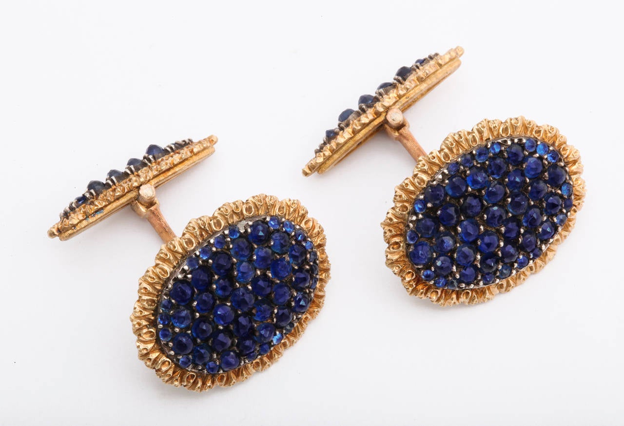 A luxurious pair of 1960s Buccellati cufflinks, each featuring a generous and beautifully matched bed of cabochon sapphires framed in fine handwrought 18K gold, the hinged backs a narrow version of the front. 7/8 inch diameter. Signed Buccellati.