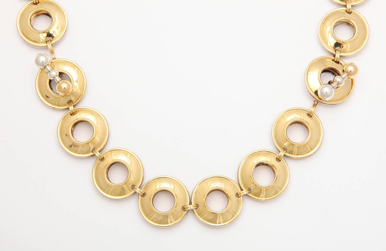Chic and versatile, this reversible 1980s Paloma Picasso design for Tiffany & Co., is of linked lifesaver disks, one side cast of 18K gold and the other of sterling silver, with the barbell toggle closures made half and half of each metal. The