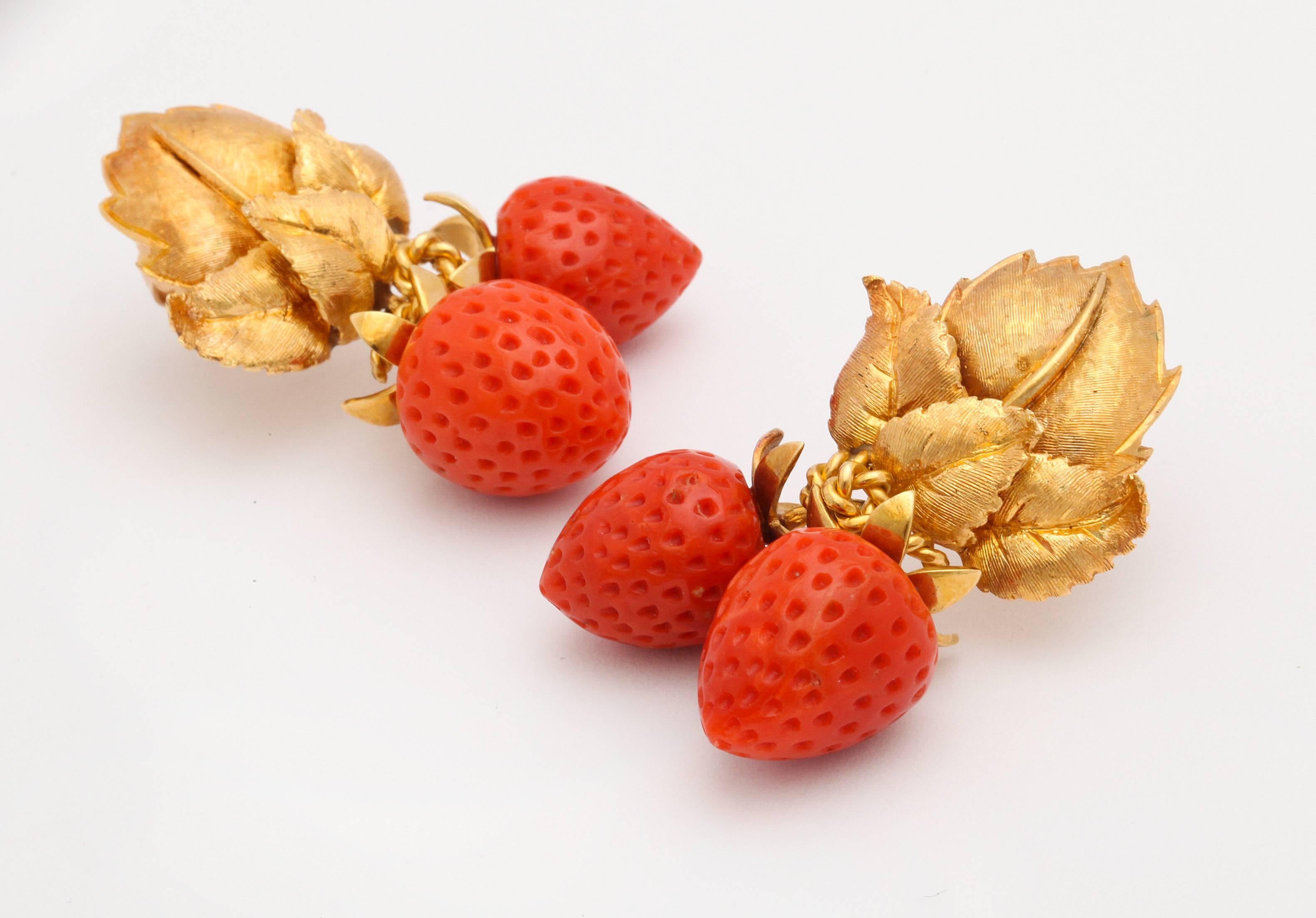 Beautiful large scale ear clips featuring hand carved strawberries of natural red orange coral suspended from highly detailed 18K rose gold multi leaf ear clips. 2 inches x 1 inch wide. 14K ear backs. 36 grams. 