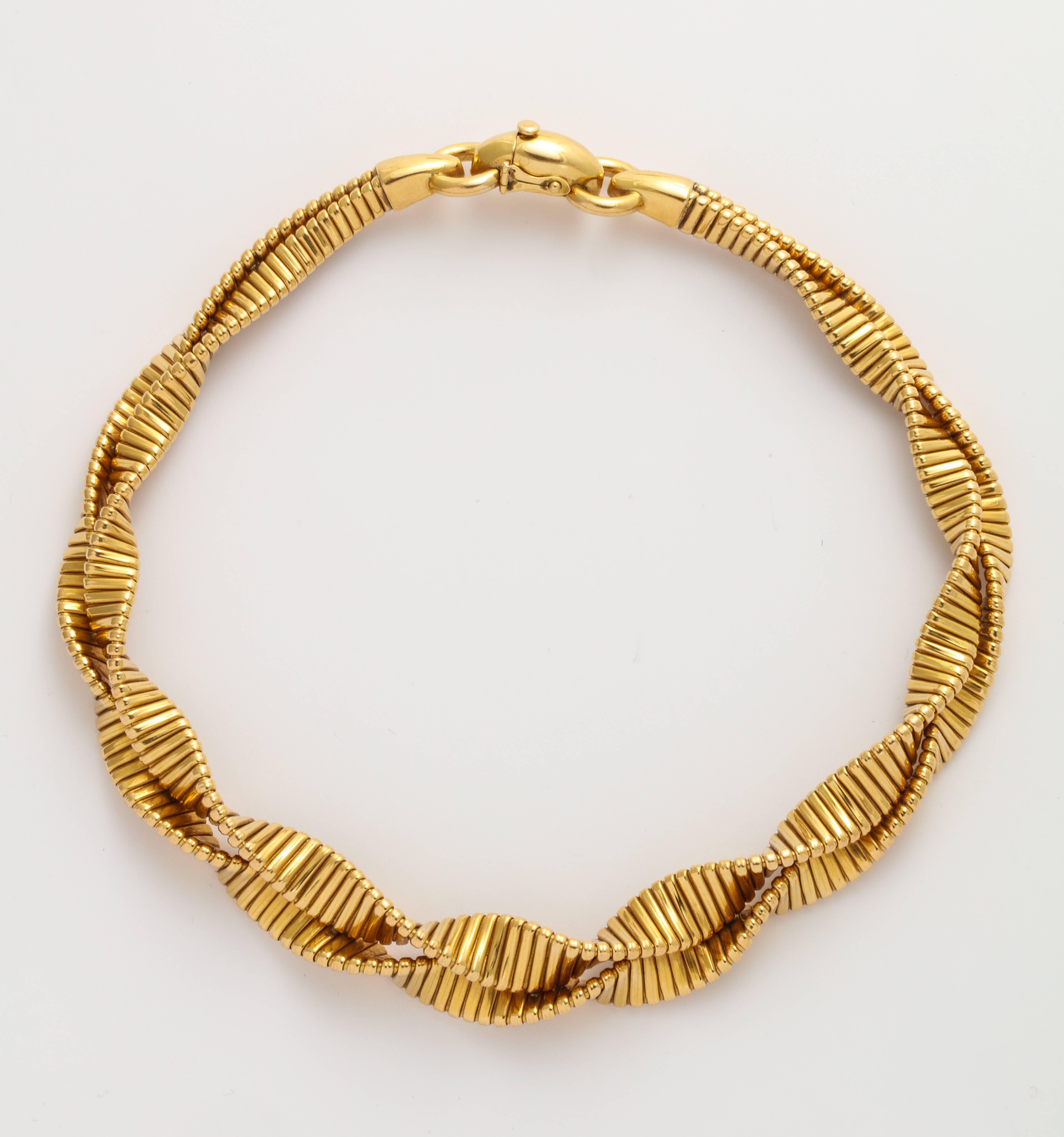 An elegant 1930s French Retro necklace and bracelet of 18K gold, in a flexible handcrafted spiral of flattened tube-gas with a beaded edge look. Each clearly marked by the maker RT and French 18K gold marks. The double wide necklace measures 3/4 in.