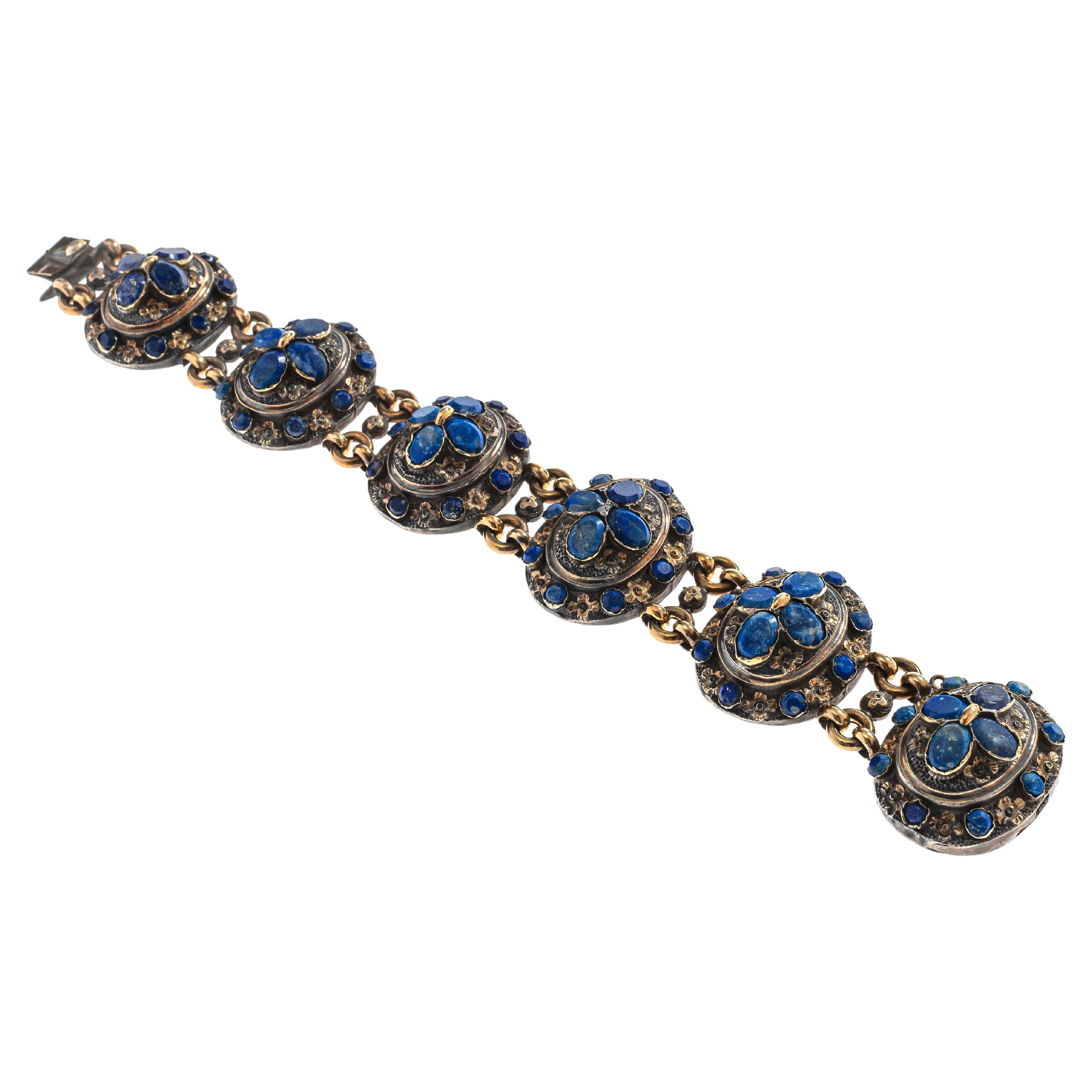 This important silver gilt bracelet is executed in Neo Gothic taste popular in France in the 1840's. The bracelet is designed as six articulated oval elements in high relief. Each element features an inner oval with a  flower made up from four oval