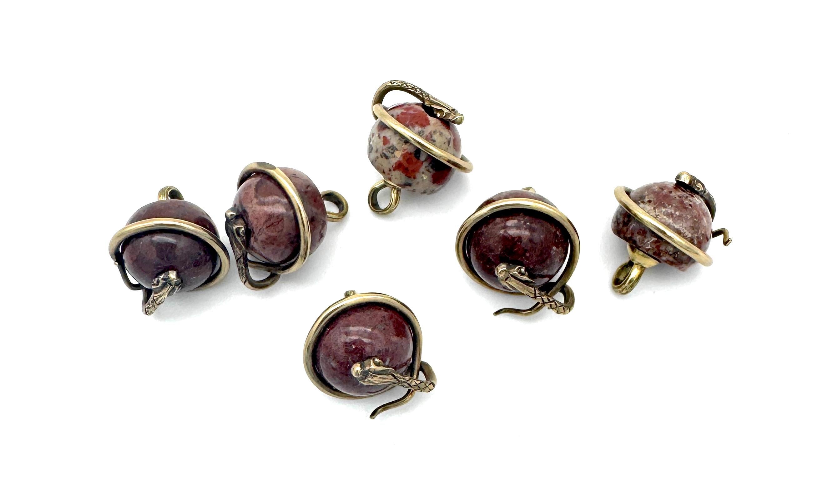 Este conjunto de seis botones se creó en la década de 1880. Los botones están tallados en mármol de distintos colores. Cada botón está decorado con una serpiente enroscada, la cabeza de la serpiente apunta al centro del botón. Las serpientes son de