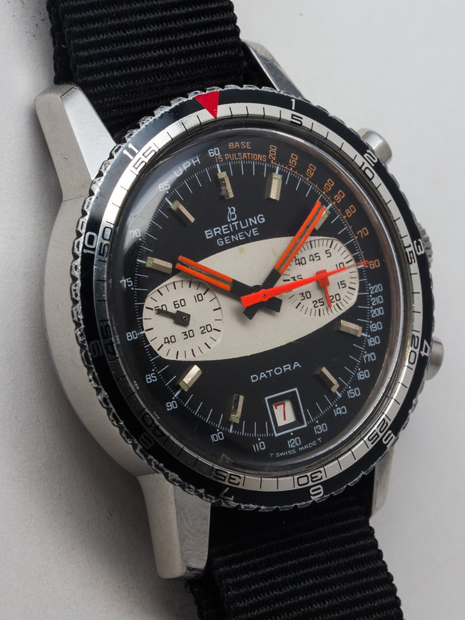 Breitling Stainless Steel Geneve Datora Wristwatch, ref 2031 circa 1970s. 39 x 48mm case with split 2 tone bezel with outer hours and inner minutes. Original black dial with contrasting white elliptical center panel, fluorescent orange painted match