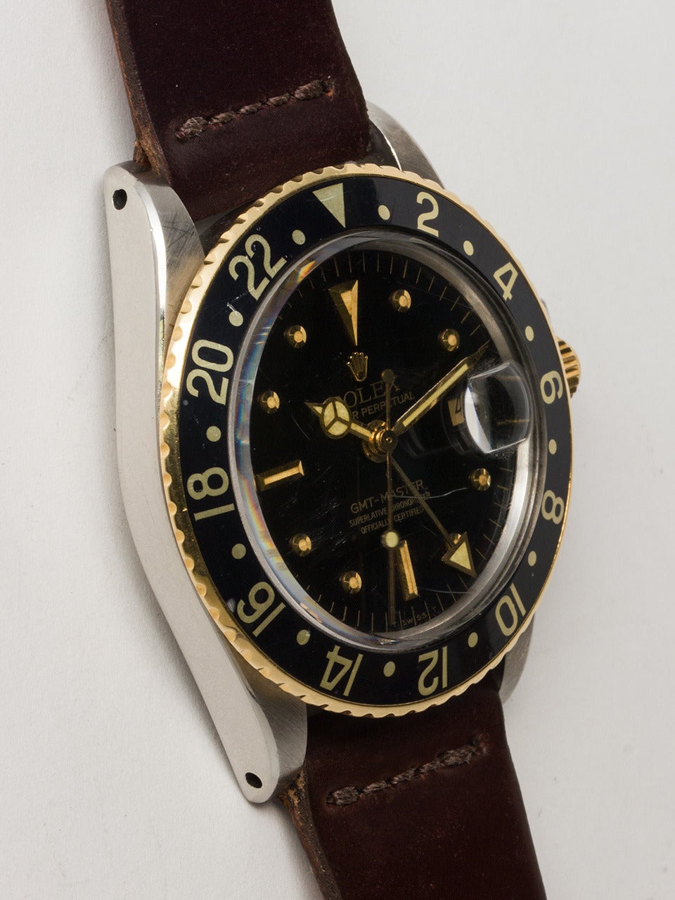Reloj de pulsera GMT Rolex de acero inoxidable y oro amarillo de 14 quilates, ref 1675 nº de serie 2,7 millones circa 1970. Caja Oyster de 40 mm de diámetro con bisel negro giratorio de 24 horas, cristal acrílico y corona con logotipo Rolex. Esfera