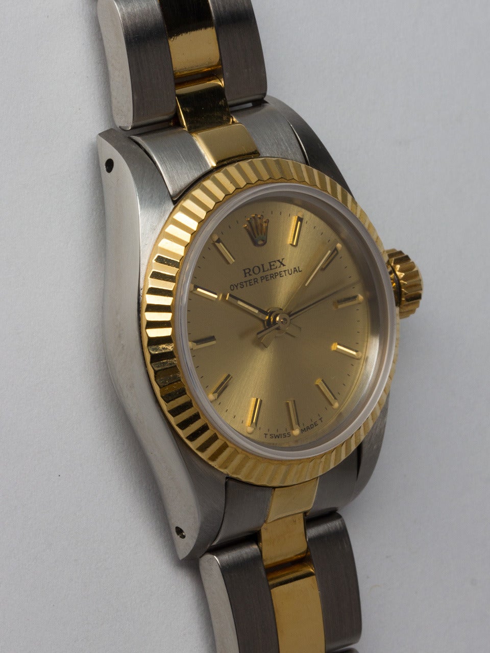 Rolex Stainless Steel and 18K Yellow Gold Oyster Perpetual Wristwatch ref 67193 serial# 8.4 circa 1984. 27mm diameter case with 18K yellow gold fluted bezel, sapphire crystal and original champagne dial with gold applied markers and hands. Self