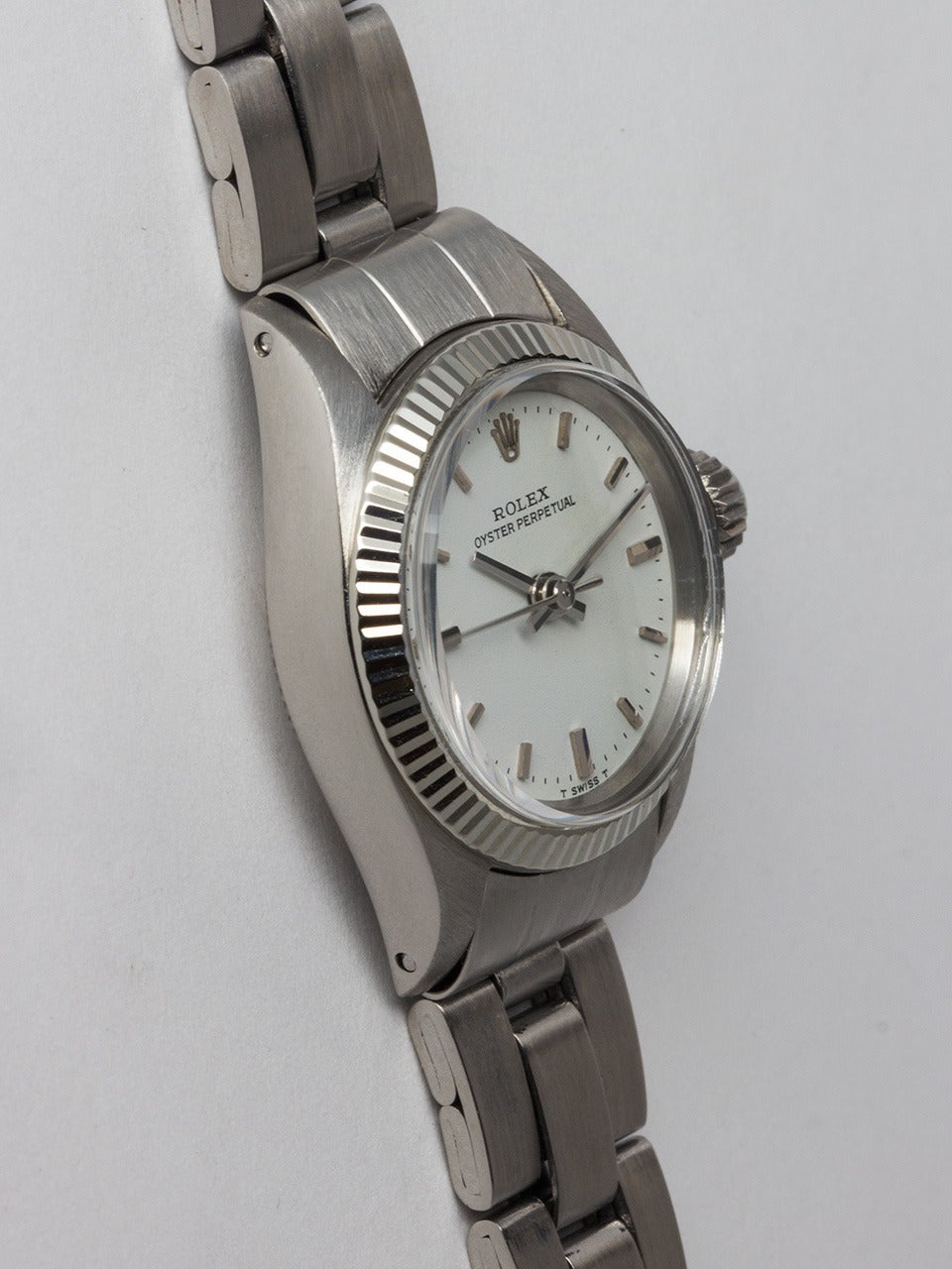 Lady's Rolex Stainless Steel Oyster Perpetual Wristwatch ref 6719 serial # 3.3 million circa 1972. 25 mm diameter Oyster case with wide 14K white gold fluted bezel and acrylic crystal. Very pleasing antique white original dial with applied silver