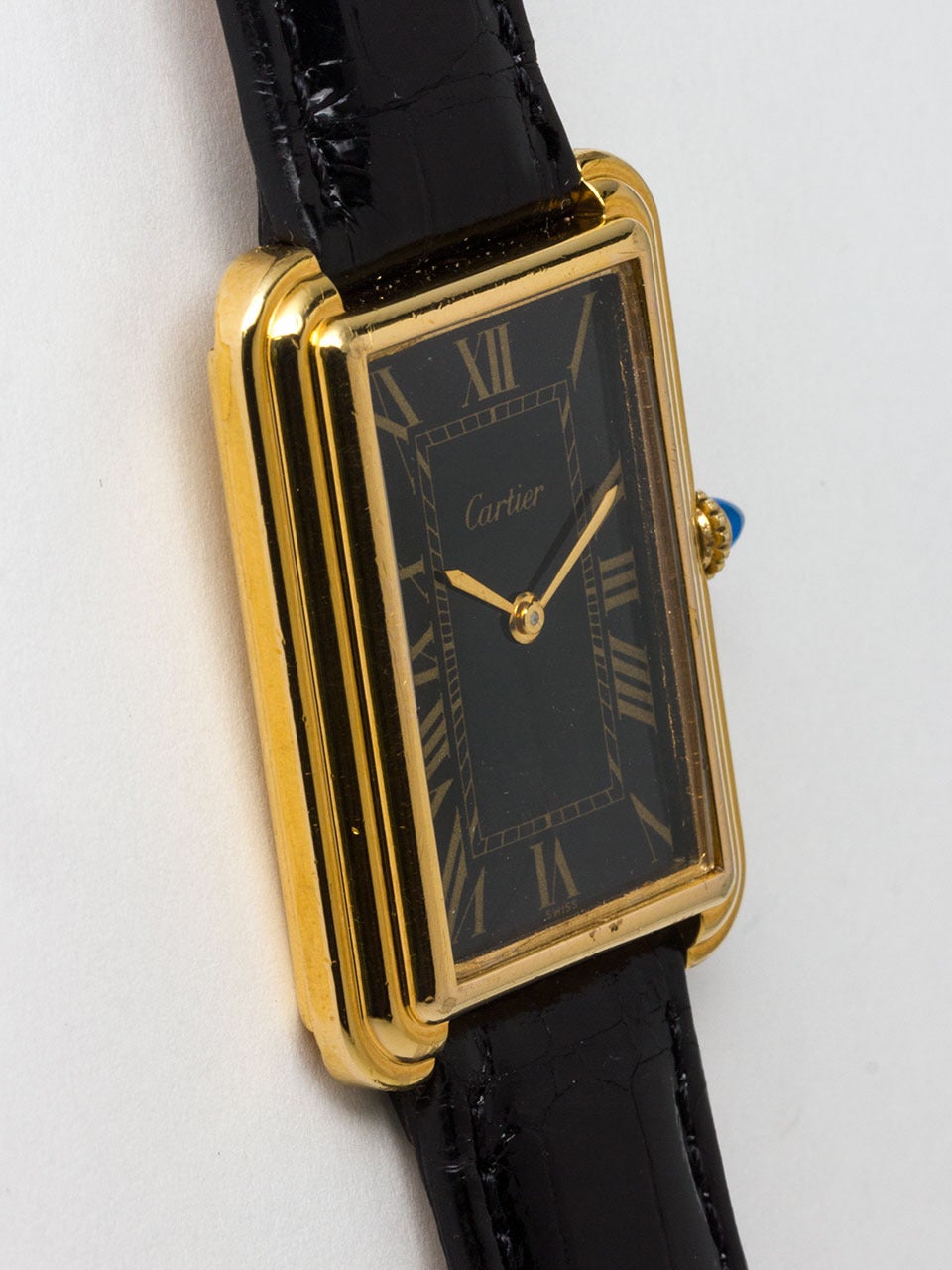 Cartier Vermeil Stepped Case Tank Wristwatch ref 12 serial # 00375 circa 1970's Case measuring 26 X 37mm with screwed case back and cabochon sapphire crown. Original black gloss dial with gold printed Roman figures and gilt hands. 17 jewel manual