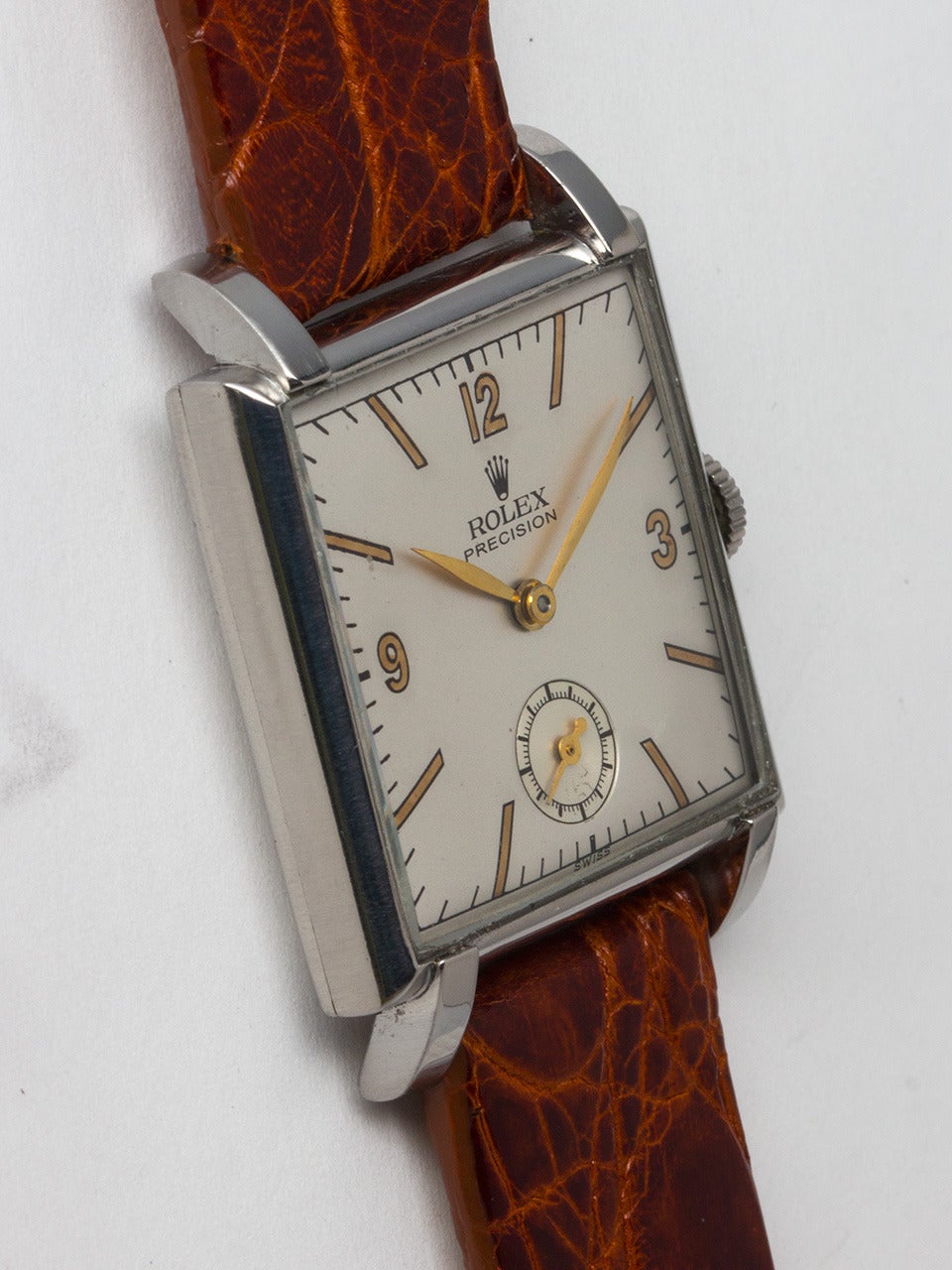 Rolex Stainless Steel Square Dress Wristwatch circa 1940s. Featuring 28 X 36.5mm snap back case with extended lugs to accommodate an 18mm strap. Beautifully restored 2 tone satin dial with mirror gold figures and gilt spade hands. Powered by 17