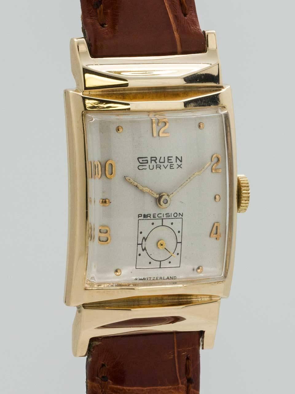 Gruen Curvex 14K YG circa 1940’s. Elongated case, measuring 24 x 36mm, with faceted hooded design and with faceted crystal. Silvered satin dial with raised gold indexes and gilt baton hands. The faceted crystal makes the text on the dial appear