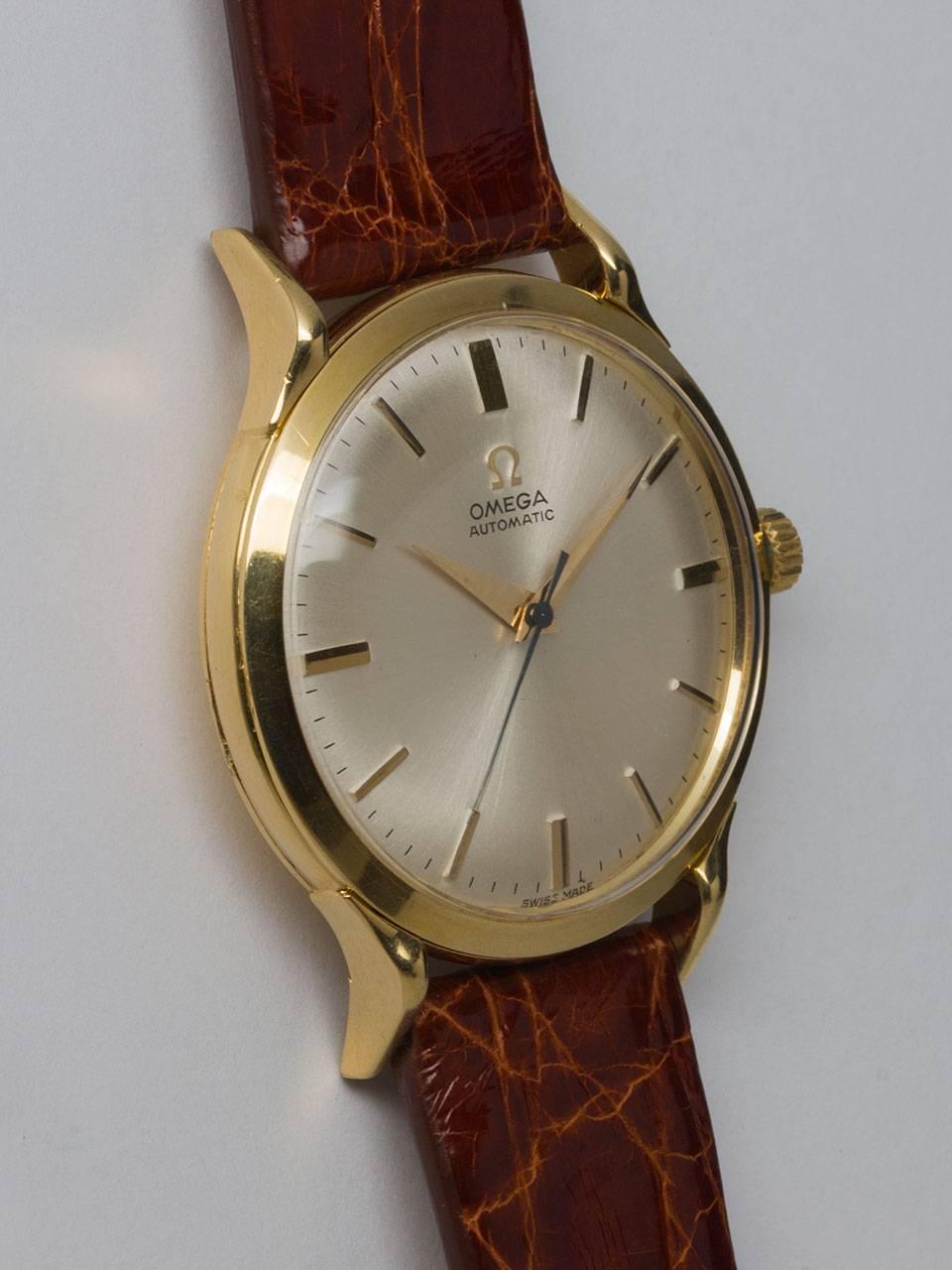 Omega 18K Yellow Gold Automatic Dress Model circa 1960s. 35 X 43mm case with extended lugs. Pleasing original matte silvered dial with gold raised indexes and tapered sword hands. Powered by self winding bump automatic movement with sweep seconds.