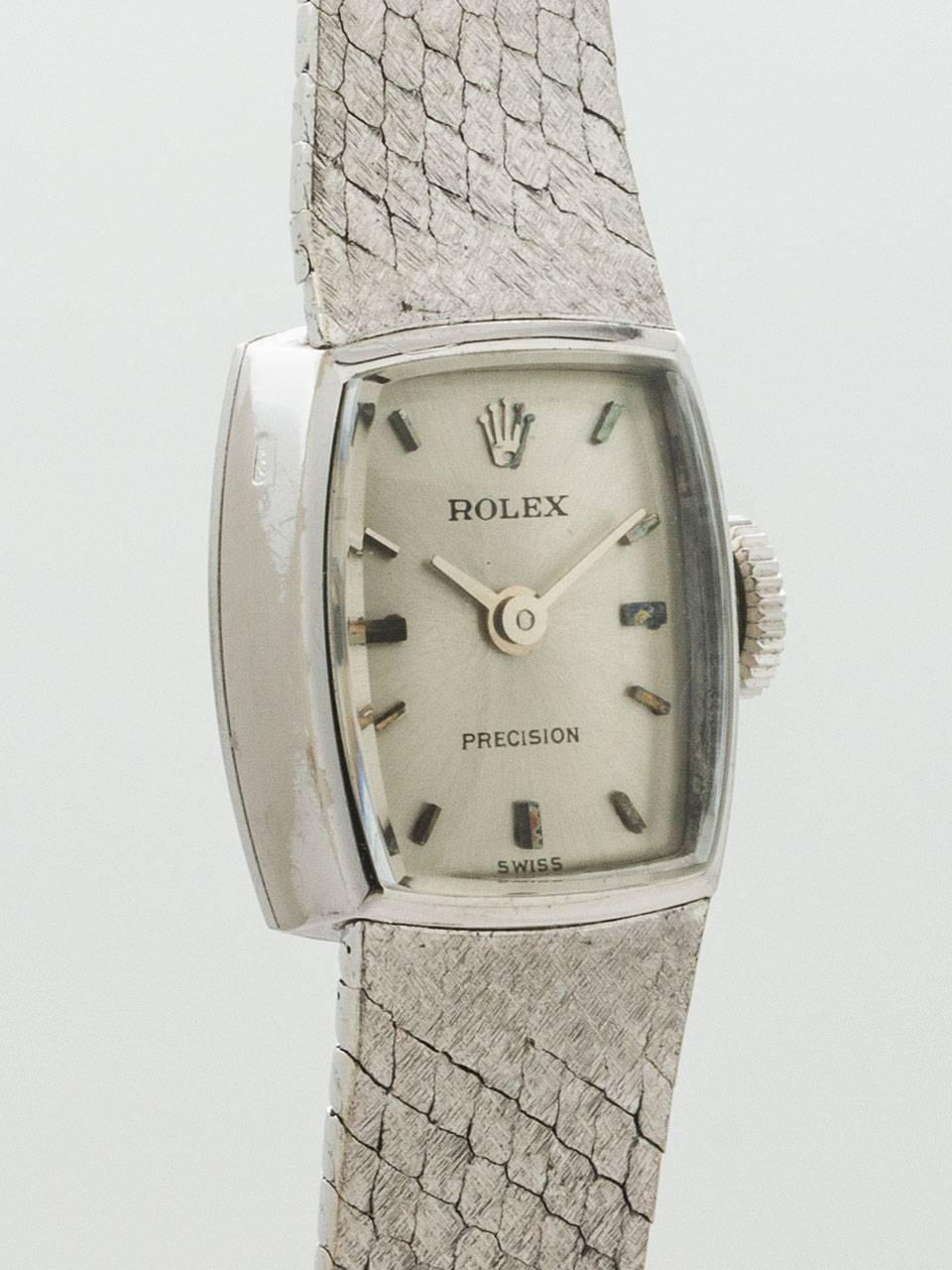 Vintage Lady's Rolex 18K White Gold Bracelet Wristwatch circa 1960s. Petite tonneau shaped case with integral heavy mesh white gold bracelet with fold over clasp. Featuring original silvered satin dial with applied silver indexes and silver tapered