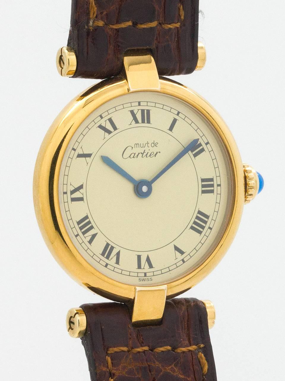 Cartier Lady’s Vermeil Vendome Tank Must de Cartier circa 1990s. 24.5 x 30mm round case with “T bar” lugs and acrylic crystal. Classic cream dial with black roman numerals, blue steeled hand, and blue cabochon sapphire crown. Battery powered quartz