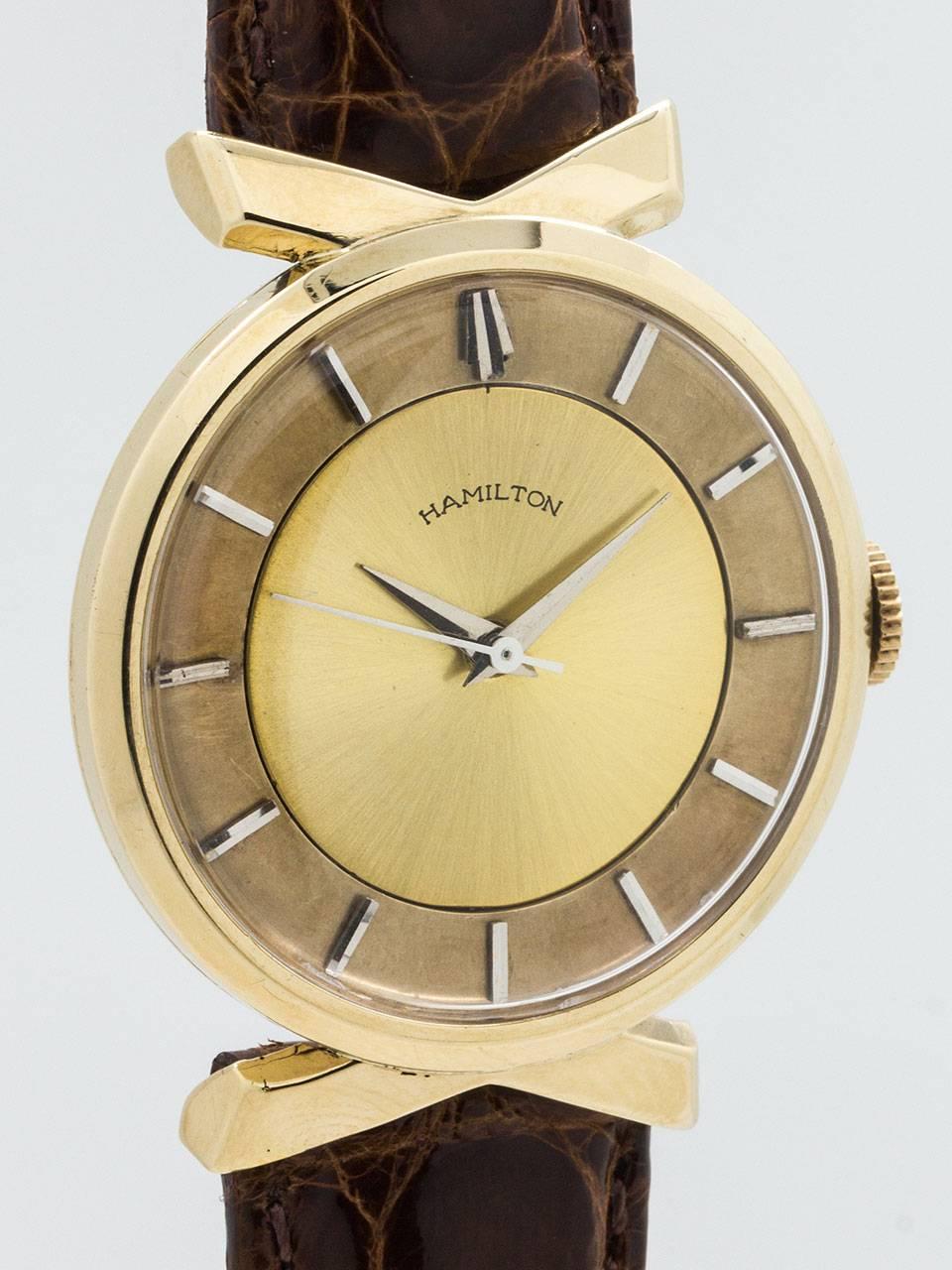 Hamilton 14K Yellow Gold “Golden Tempus” man’s vintage dress model circa 1957. Featuring a distinctive modernist case design 33.2 x 40.9 case with overlapping “fin” shaped lugs. Original 2 tone champagne dial with applied silver indexes and tapered