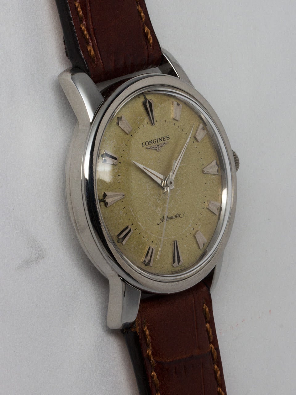 Longines Stainless Steel Automatic Wristwatch circa 1950s. Large and robust 35.5 x 43mm case with wide bezel with heavy extended lugs and screw down water proof style case back . Very pleasing original warmly patina'd matte silvered dial with large