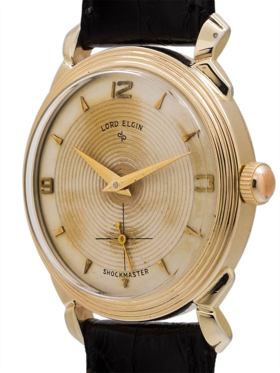 
Very cool “retro” design vintage man’s Lord Elgin manual wind dress model circa 1950’s. Featuring 32mm diameter screw back case with extended 40mm fancy lobed lugs, finely stepped bezel that matches the original antique white dial with finely