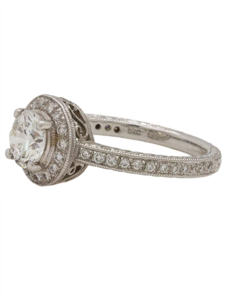 
This gorgeous 18k white gold New Vintage engagement ring is reminiscent of the 1920s and showcases a stunning 1.03ct GIA certified round brilliant cut diamond, E-SI1. This ring is brimming with detail from the hand engraved shank to the scroll