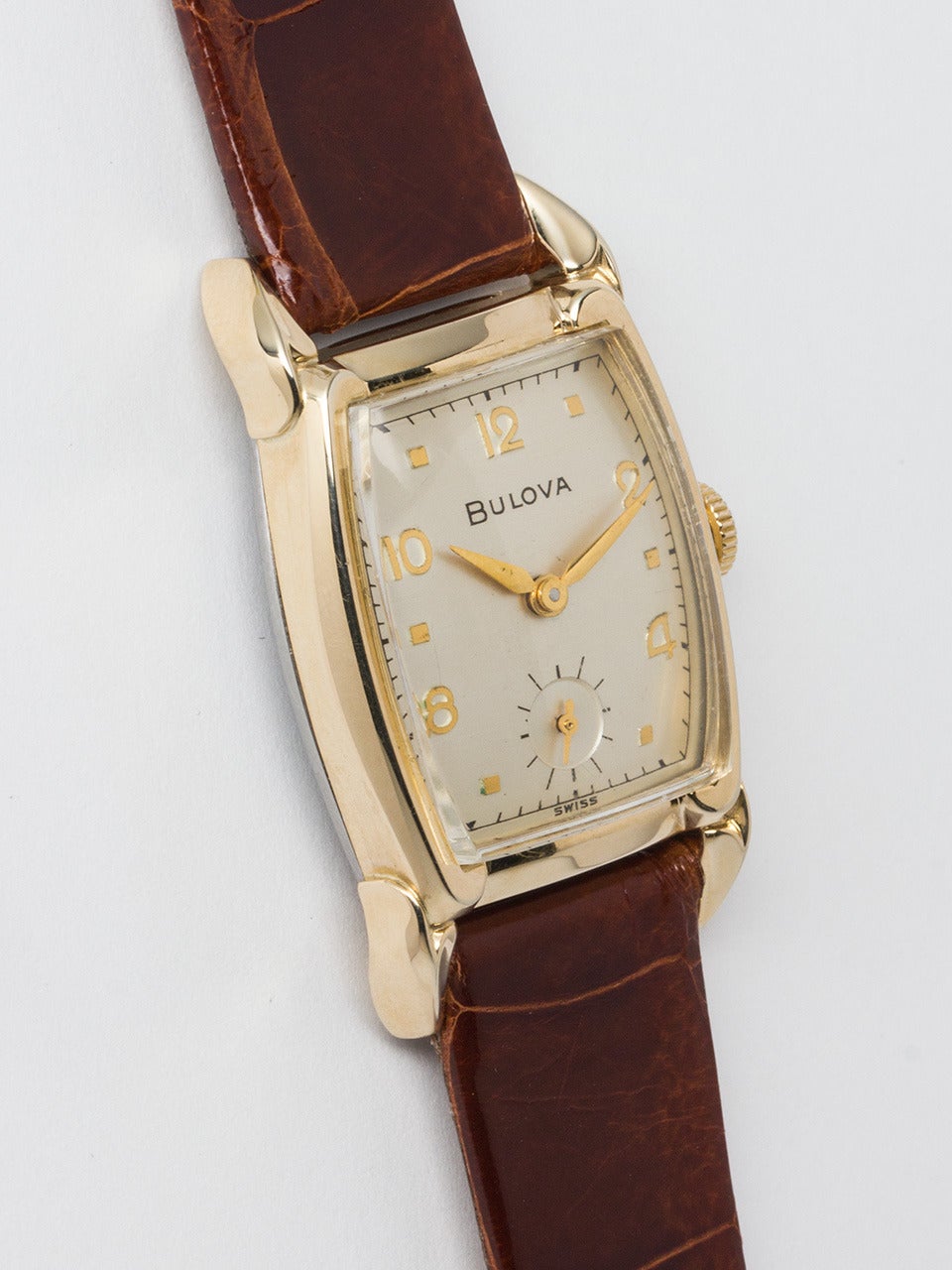 Bulova Yellow Gold Filled Dress Wristwatch circa 1950s. Tonneau shaped 25 X 40 mm case with original satin silvered dial with raised gold numerals and dots and tapered gilt hands. Powered by 17 jewel manual wind caliber 10BT movement with subsidiary