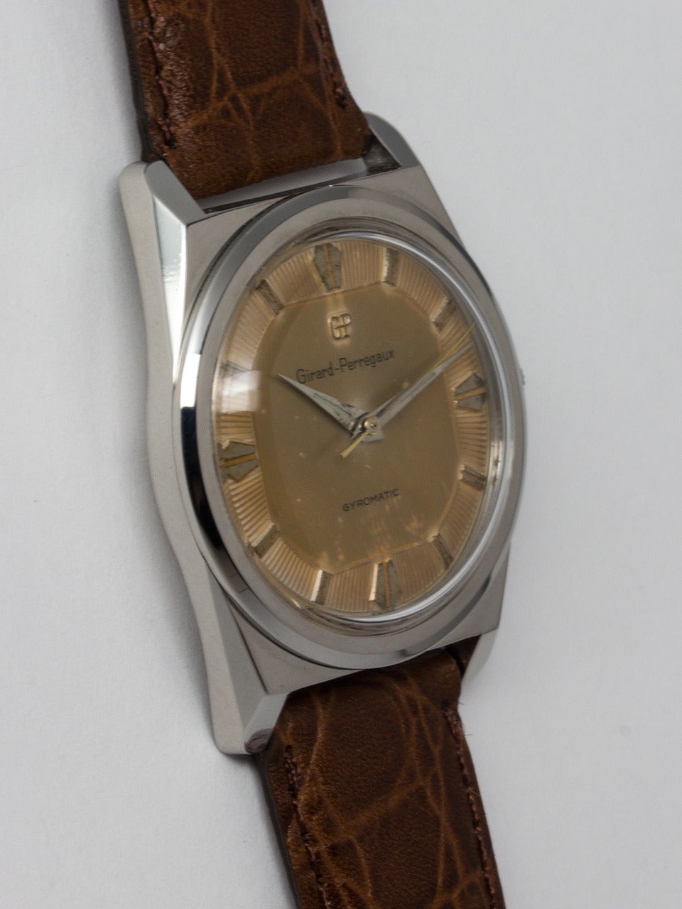 Girard Perregaux Stainless Steel Gyromatic Wristwatch circa 1960s. Unusual design 34 X 42mm faceted case with patina'd original dial with textured background and raised silver indexes and tapered sword hands. Powered by self winding caliber 21