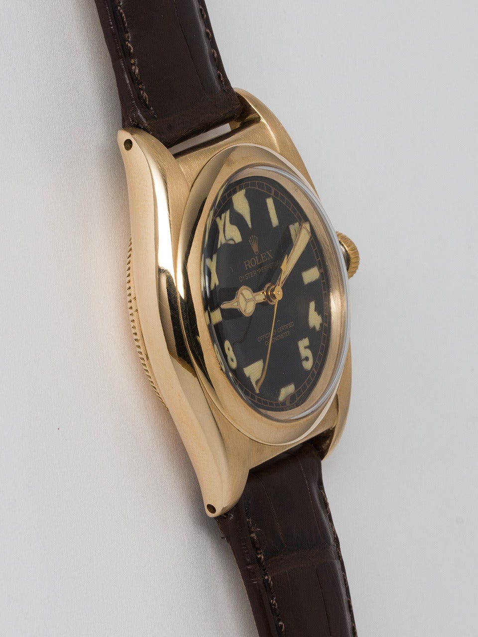 Rolex 14K Yellow Gold Bubbleback Wristwatch circa 1940s. 32mm diameter case with smooth bezel and acrylic crystal. Beautifully restored glossy black so called 