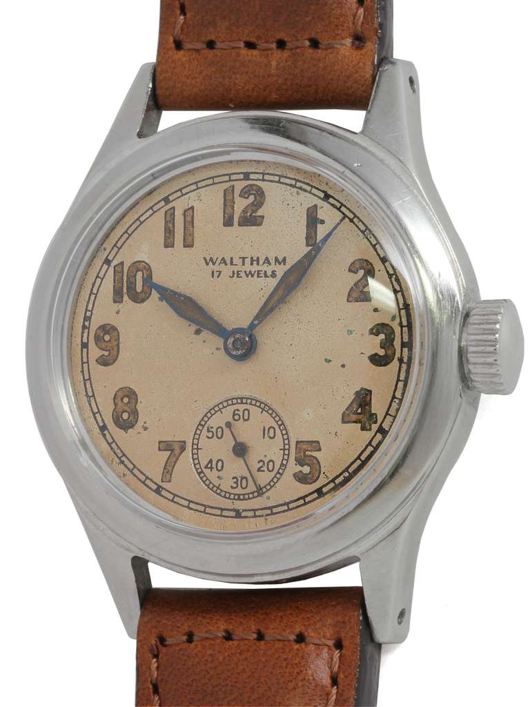 Waltham base metal WWII-era military wristwatch, circa 1940s. Brushed finish case, 32 X 39mm, with screw back and original warmly patinaed dial with luminous Arabic numerals and luminous feulle hands. Powered by a 17-jewel manual-wind movement with