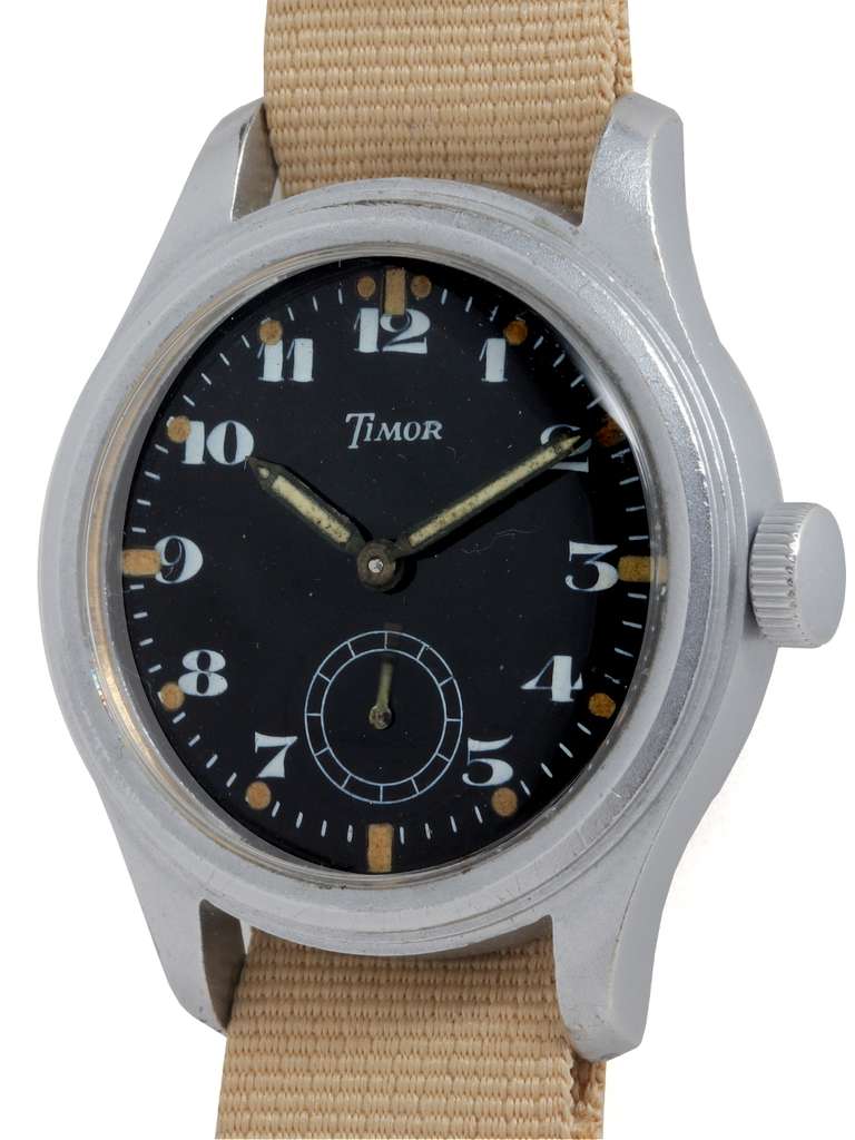Timor brushed base metal British military Broad Arrow wristwatch, Ref. 9496, circa 1945. Brushed metal case measuring 36.5 x 46mm. Great looking black enamel dial with Arabic numerals, large patinaed luminous dots and subsidiary seconds hand. Screw