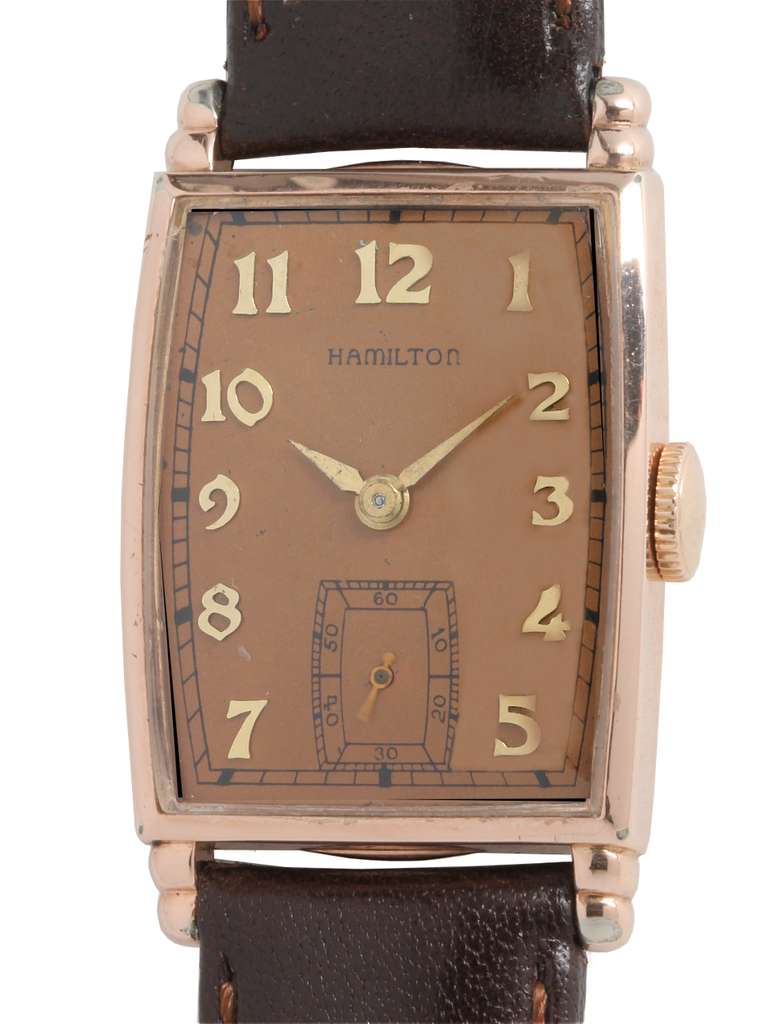 Hamilton rose gold-filled Myron tonneau wristwatch, circa 1940s. 23 X 37mm case with stepped lugs. Original salmon dial with applied Arabic numerals and alpha hands. 17-jewel manual-wind calibre 982 movement with subsidiary seconds. Great looking