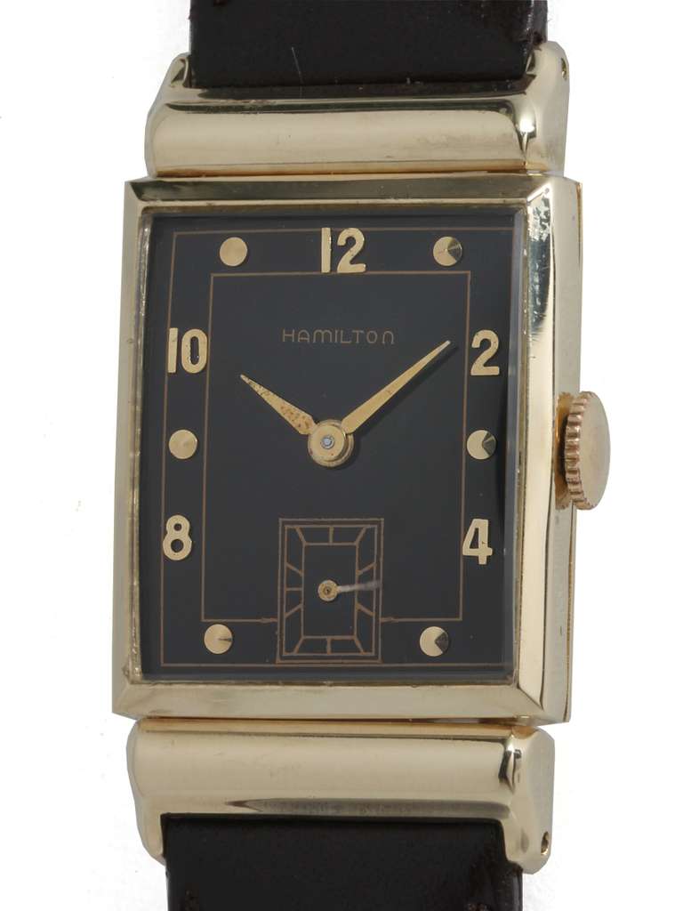 Hamilton 14k yellow gold rectangular Barton wristwatch, circa 1950s. Featuring angular hooded lugs, glossy black dial with applied Arabic and dot indexes and alpha hands. 17-jewel manual-wind calibre 982 movement with subsidiary seconds. Free of any