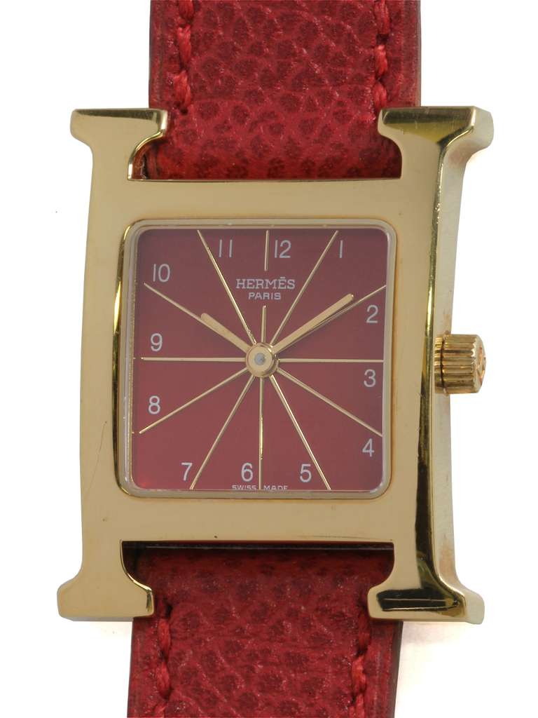 Hermes lady's gilt red H Hour wristwatch, circa 2000s. 23 X 30mm gilt case in mint condition with red dial, printed numbers and mint red leather strap with Hermes buckle. Very mint condition, appears unworn.

Like all our watches, this classic