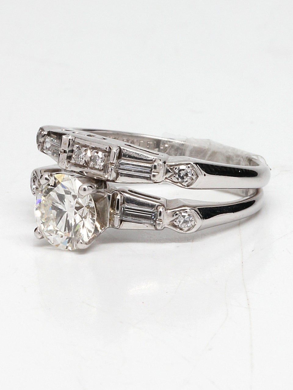 Striking platinum Retro diamond wedding set, featuring a stunning EGL certified 0.93ct I-VS1. Baguette and round cut side diamonds set in a geometric motif perfectly compliment the center stone. Total weight is approximately 1.20ct. Great original