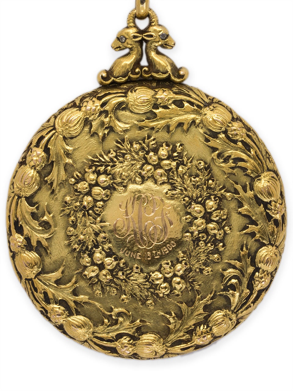 Ornate and fabulous large (silver dollar size) 18K yellow gold turn of the century repousse locket with a milk thistle wreath encircling another botanical wreath. Two goats with tiny diamond eyes grace the top at the bail.  1 3/4