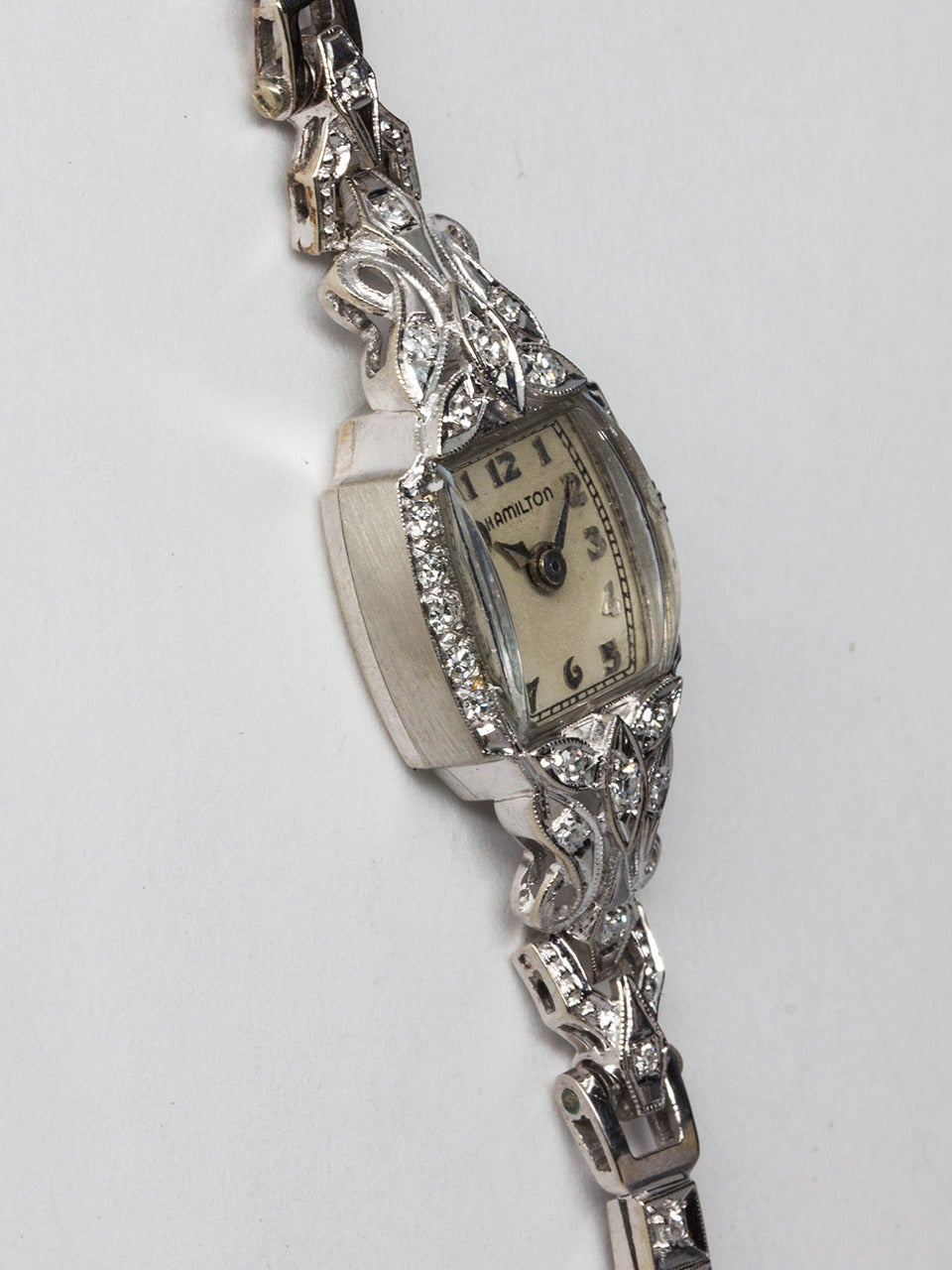 Lady Hamilton 14K White Gold Diamond Dress Wristwatch circa 1940s. Marquise shaped watch with hinged lugs and with associated 14K white gold diamond set box link bracelet with clasp. Very pretty model with dome crystal, matte silvered dial with