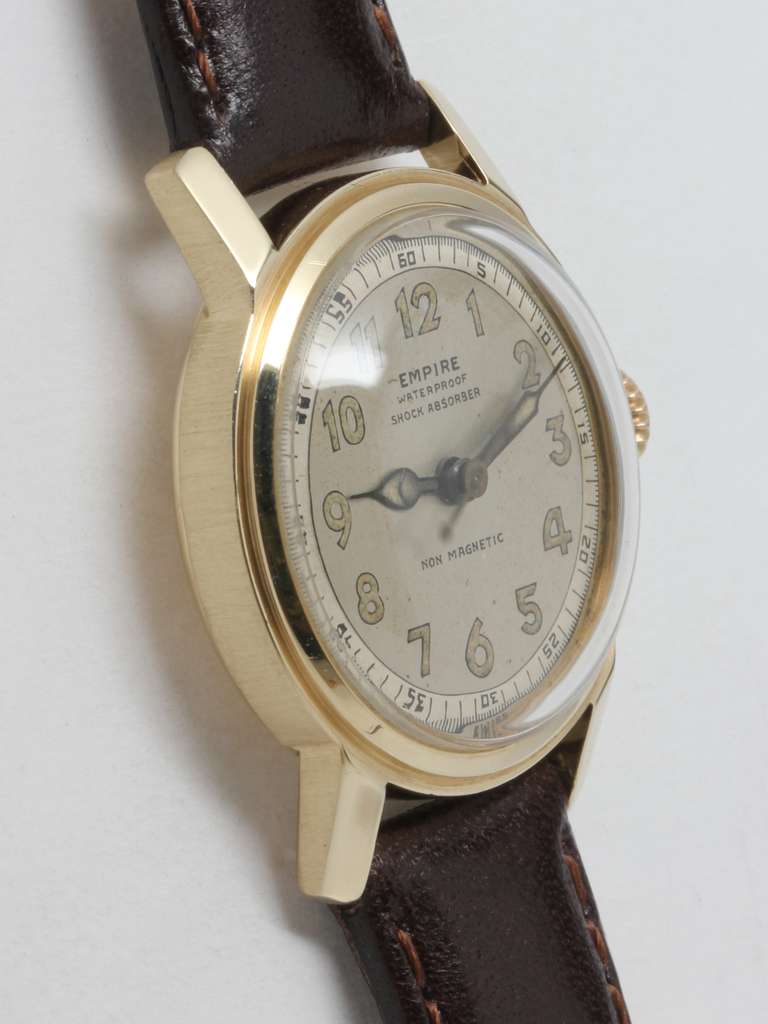 Empire 14k yellow gold wristwatch with sweep center secongs, circa 1950s. 29 X 35mm case with stepped bezel, screw back. Very pleasing original matte silvered dial with patinaed luminous indexes and matching pencil hands. 17 jewel manual-wind