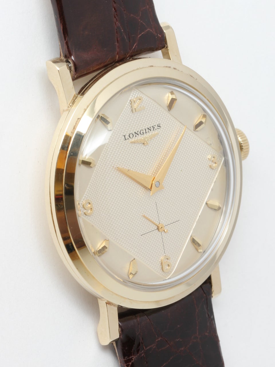 Longines 14K Yellow Gold Dress Model Wristwatch circa 1950s. 34mm diameter case with wide stepped bezel. With beautiful original 2 tone textured antique white and satin dial with baseball diamond pattern with gold raised indexes and tapered gold