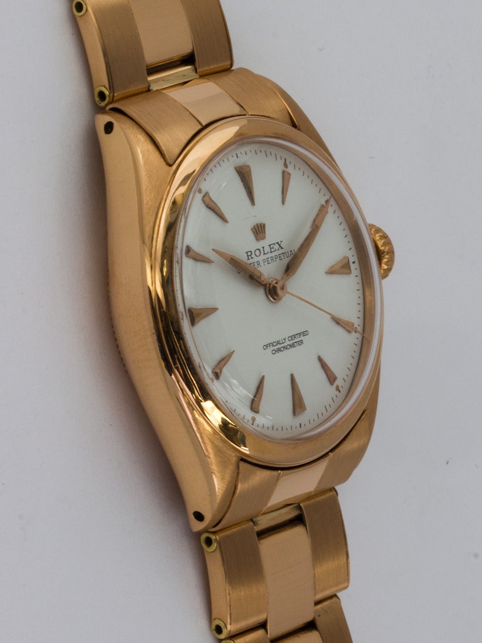Rolex 18K Rose Gold Oyster Perpetual Wristwatch ref 6084 circa 1956. 34mm diameter Oyster case with smooth bezel and acrylic crystal. Lovely refinished white dial with applied triangular indexes and tapered sword hands. Powered by self winding
