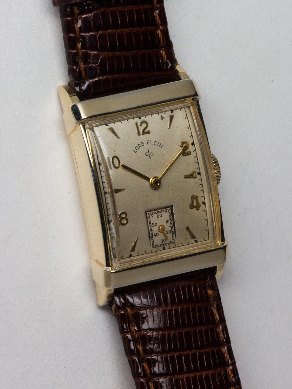 Lord Elgin Yellow Gold Filled Dress Model Wristwatch circa 1940s. Rectangular case measuring 35 x 21mm with low domed crystal. Original matte silvered dial with applied even numbers and alternating triangular markers. Powered by manual wind movement