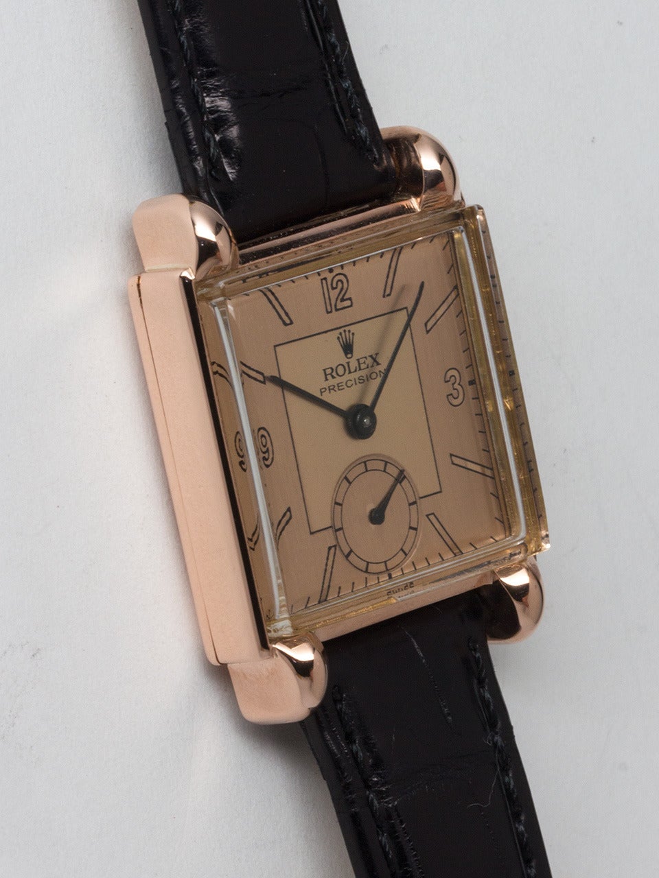 Rolex 14K Rose Gold Square Dress Wristwatch circa 1940s. Square case measuring 26 x 35mm with horn lugs. Beautifully restored 2 tone salmon dial with mirror figures and baton hands. Powered by 17 jewel manual wind caliber 10 1/2 H movement with