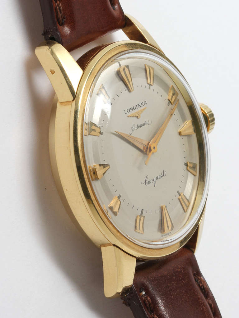 Longines 18K Yellow Gold Conquest circa 1960s. Robust 35 X 42mm screw back case with wide bezel. Beautiful original 2 tone dial with gold applied indexes, matching dauphine hands, and self winding movement. Caseback features blue enameled Conquest