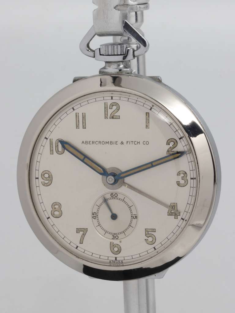 Abercrombie & Fitch stainless steel travel alarm pocket watch and night stand watch, circa 1950s. Chromium plated metal case with hinged back to stand up as a night stand alarm clock. Very pleasing original matte silvered dial with luminous Arabic