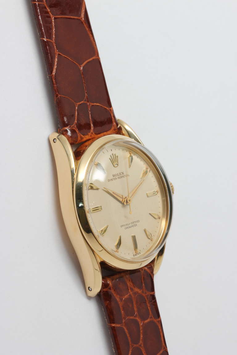 Rolex 18k yellow gold Bombe wristwatch, Ref. 6590, serial number 120,XXX, circa 1955. Fabulous looking model with heavy bombe lugs and domed acrylic crystal. Stunning original patinaed cream dial with gold applied marquise-shaped indexes, dauphine